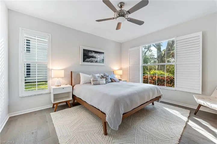Bedroom featuring multiple windows, ceiling fan, and light hardwood / wood-style floors