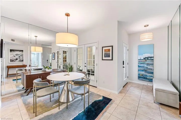Dining area featuring light tile patterned floors and french doors