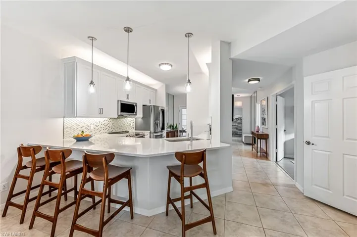 Kitchen with pendant lighting, tasteful backsplash, sink, kitchen peninsula, and stainless steel appliances
