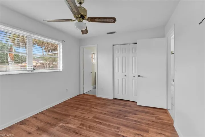 Unfurnished bedroom featuring wood finished floors, ceiling fan, and a closet