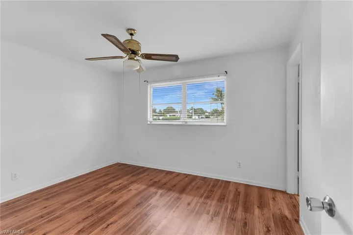 Unfurnished room with wood finished floors and a ceiling fan