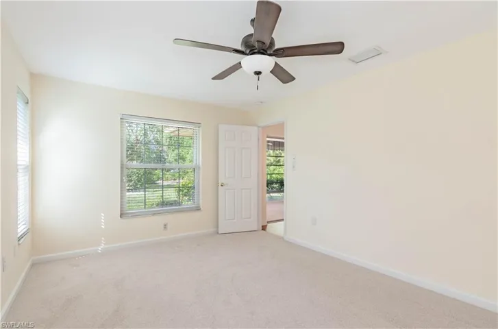 Empty room featuring ceiling fan and light colored carpet