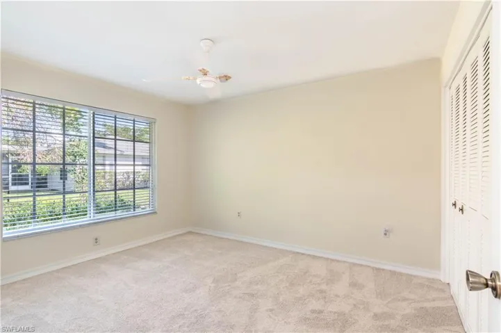 Carpeted bedroom featuring ceiling fan