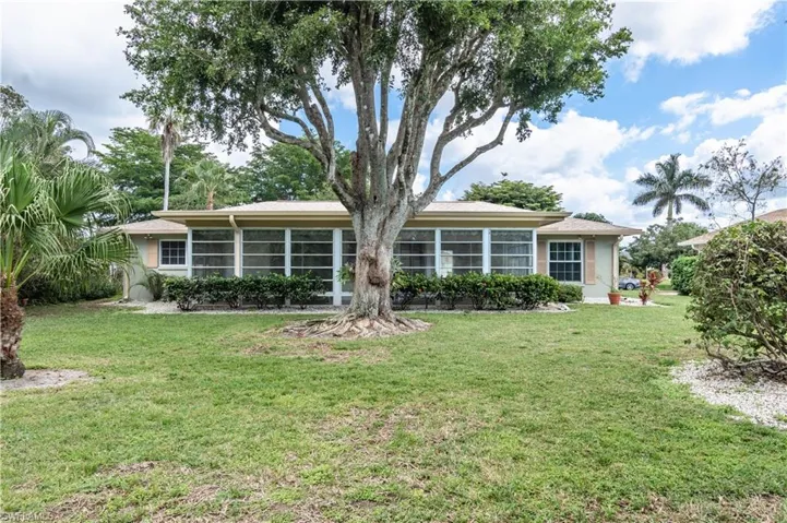 Back of property featuring a yard and a sunroom