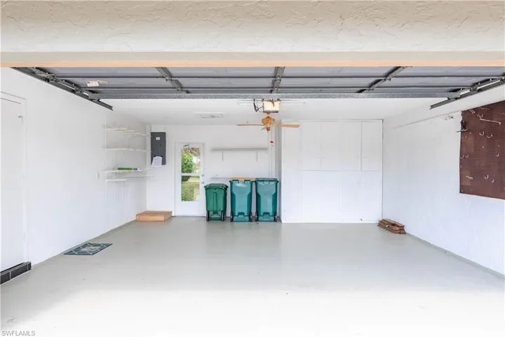 Garage featuring a garage door opener and electric panel