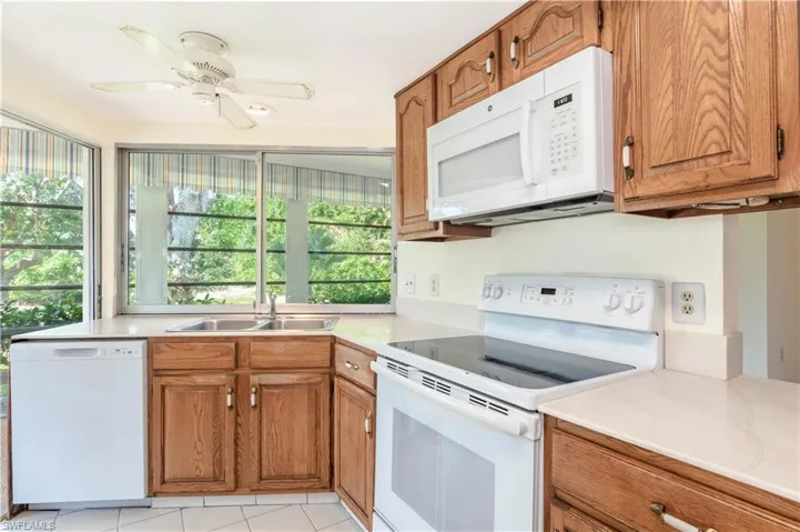 Kitchen with ceiling fan, sink, and white appliances