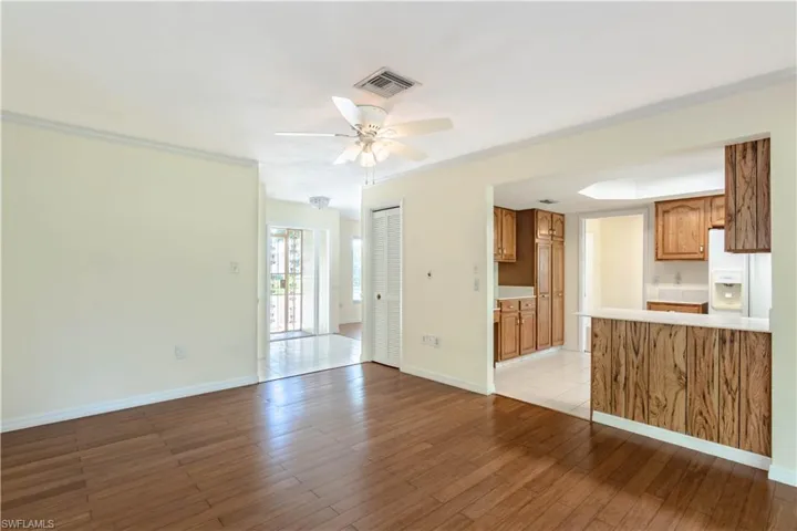 Unfurnished living room with crown molding, ceiling fan, and light hardwood / wood-style flooring
