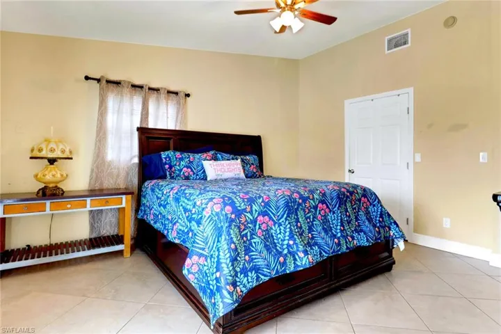 Bedroom with light tile patterned floors and ceiling fan