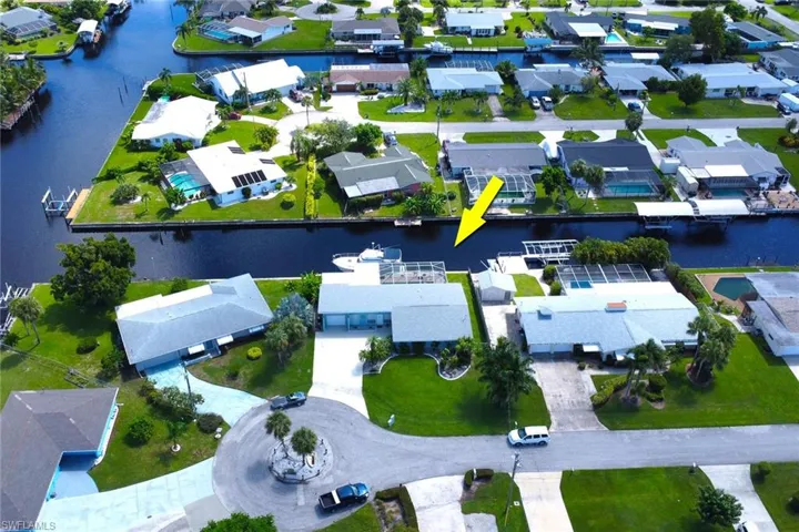 Aerial view of property and surrounding area featuring nearby suburban area and a nearby body of water