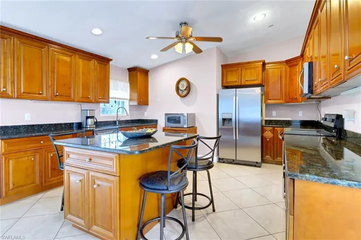 Kitchen with appliances with stainless steel finishes, brown cabinets, light tile patterned flooring, and recessed lighting
