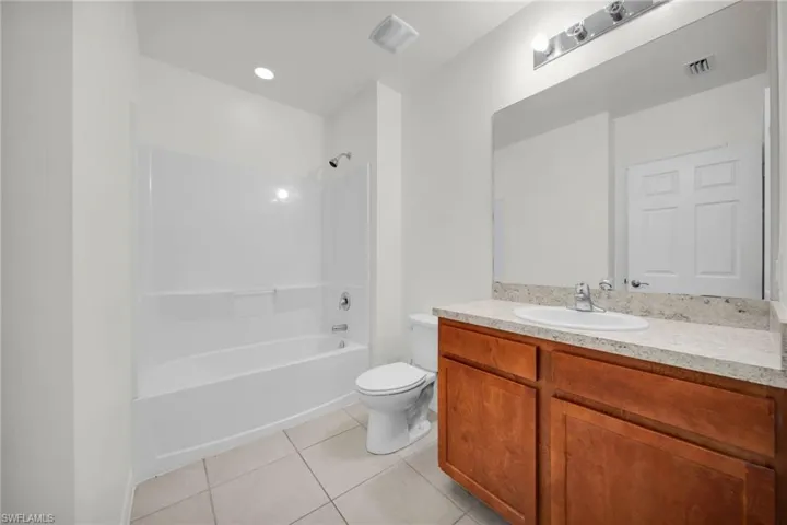 Bathroom featuring a spacious vanity with wood cabinetry, a light-toned countertop, and an integrated sink