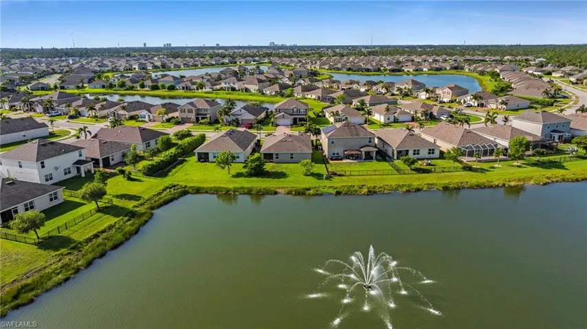Waterfront community featuring single-family homes, manicured lawns, and mature landscaping
