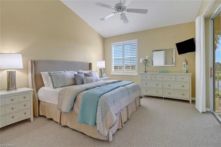 Bedroom featuring light colored carpet, access to outside, lofted ceiling, and ceiling fan