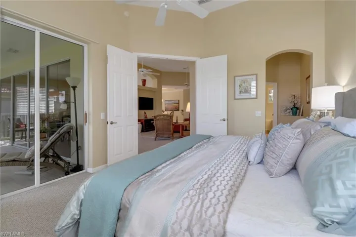 Bedroom featuring carpet, access to outside, a towering ceiling, and ceiling fan