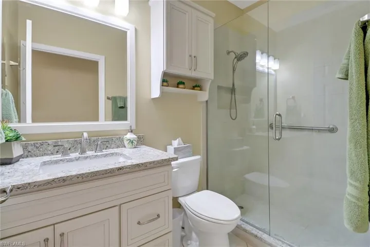 Bathroom with an enclosed shower, toilet, and vanity