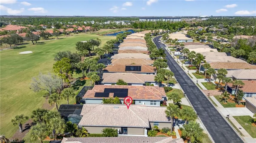 Aerial view of residential area with a local golf course and a nearby body of water