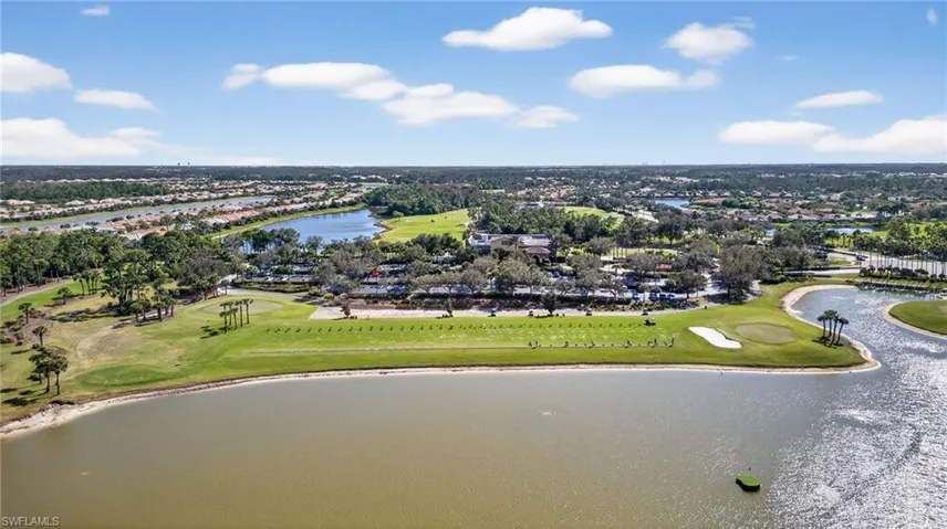 Aerial perspective of suburban area featuring a golf club and a nearby body of water