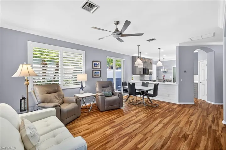 Living area featuring ornamental molding,  ceiling fan, and arched walkways