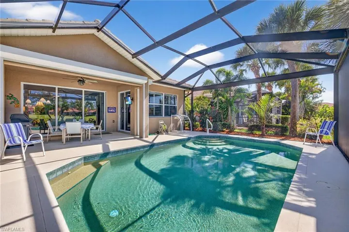 Swimming pool featuring a patio, a sunroom, outdoor dining area, and a lanai
