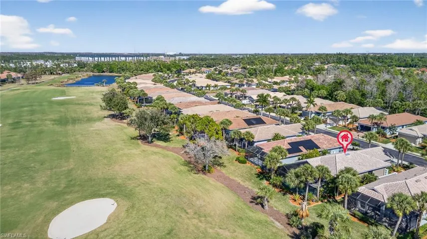 Aerial view of residential area with a nearby body of water and a golf course