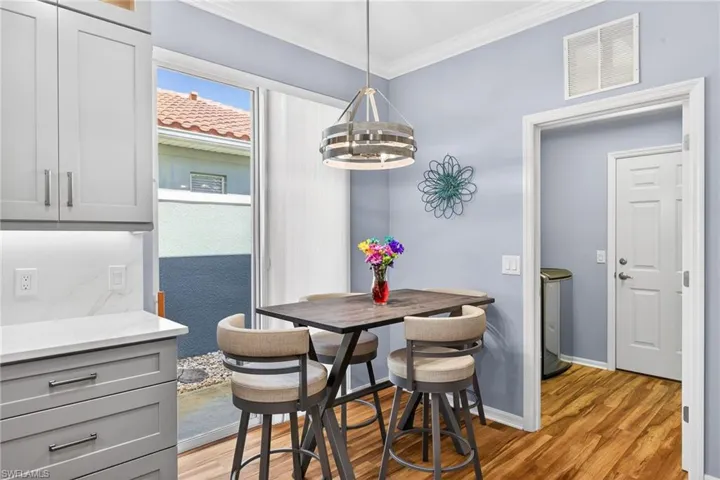 Dining room featuring ornamental molding, light wood finished floors, and washer / dryer