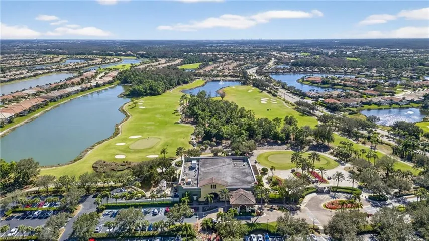 Aerial perspective of suburban area with a golf club and a large body of water