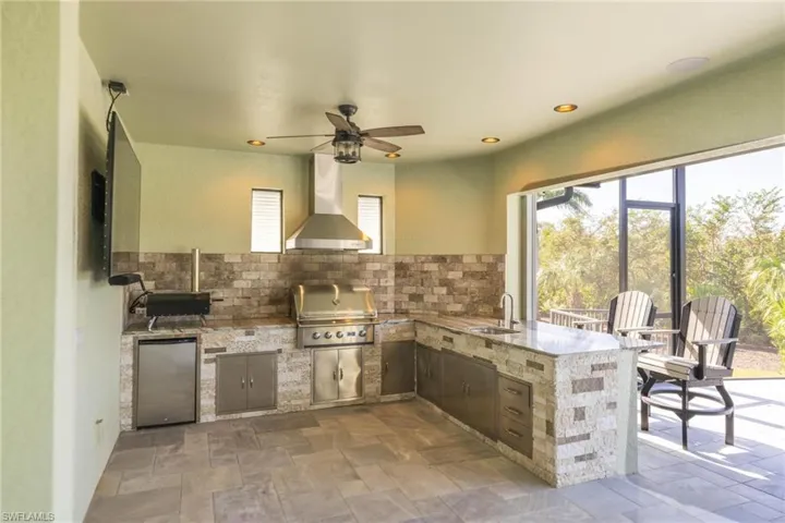 View of patio / terrace with sink, ceiling fan, grilling area, and an outdoor kitchen