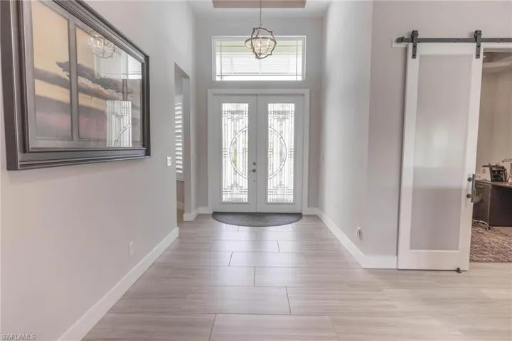 Entrance foyer with french doors, a barn door, and light wood-type flooring