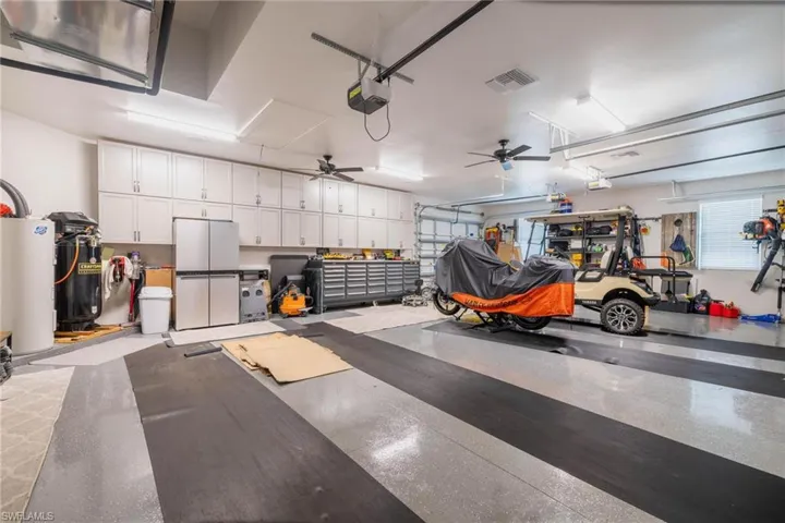 Garage featuring ceiling fan, a garage door opener, and gas water heater