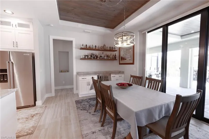 Dining room featuring an inviting chandelier, wood ceiling, and a tray ceiling