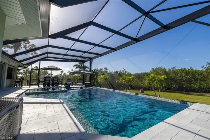 View of swimming pool with a patio area and glass enclosure