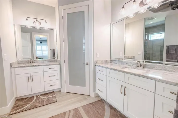 Bathroom with a shower with door, vanity, hardwood / wood-style flooring, and a healthy amount of sunlight