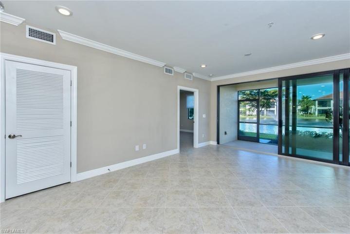 Living area with door to AC closet & door to primary suite just before sliders to lanai & lake view