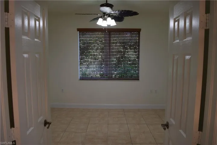 Unfurnished room with ceiling fan and light tile patterned floors