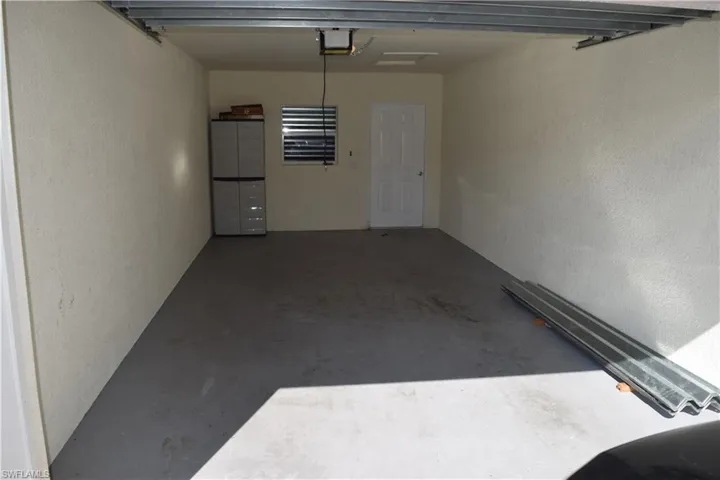 Garage with a textured wall and a garage door opener