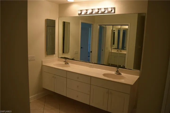 Bathroom featuring double vanity and light tile patterned floors