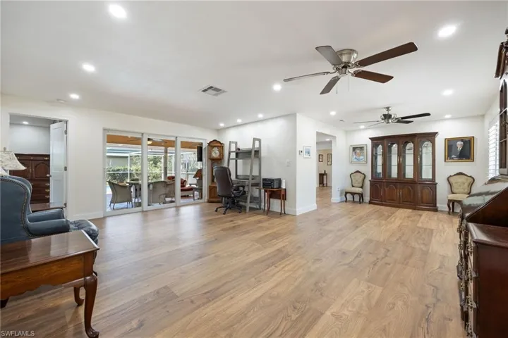 Living area with light wood finished floors, visible vents, ceiling fan, and recessed lighting