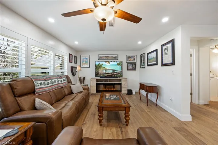 Living area with baseboards, ceiling fan, recessed lighting, and light wood-type flooring