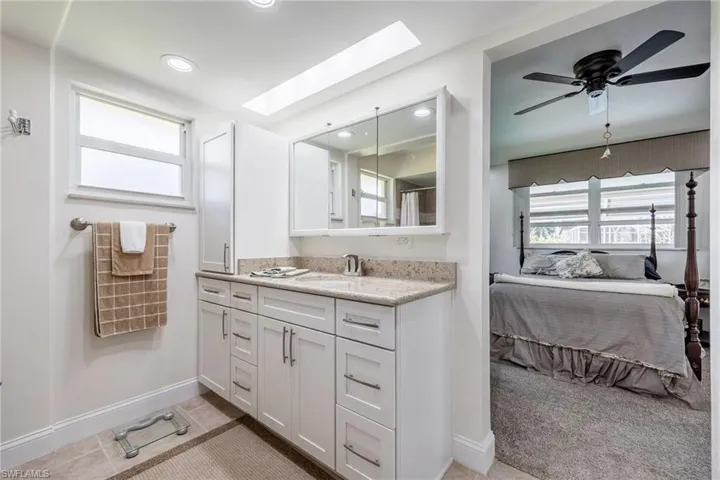 Bathroom with a healthy amount of sunlight, vanity, a skylight, and ensuite bath