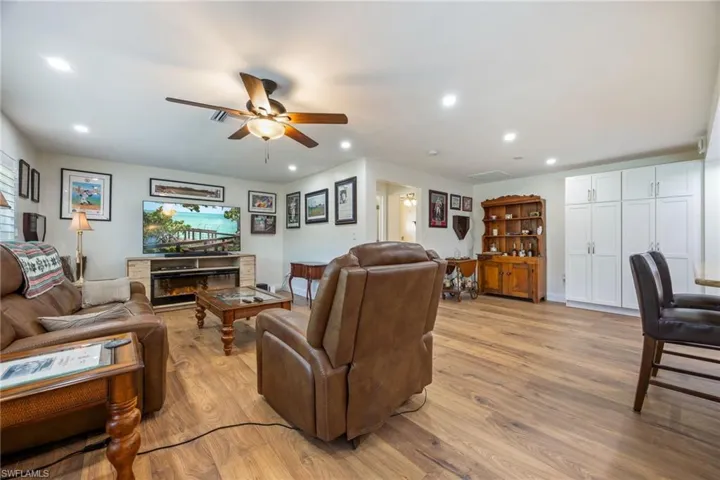 Living room featuring light wood-style flooring, ceiling fan, and recessed lighting