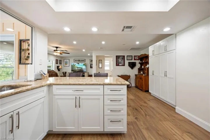 Kitchen with a wealth of natural light, visible vents, recessed lighting, and a peninsula