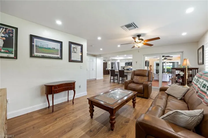 Living room with recessed lighting, baseboards, light wood-style floors, ceiling fan, and visible vents