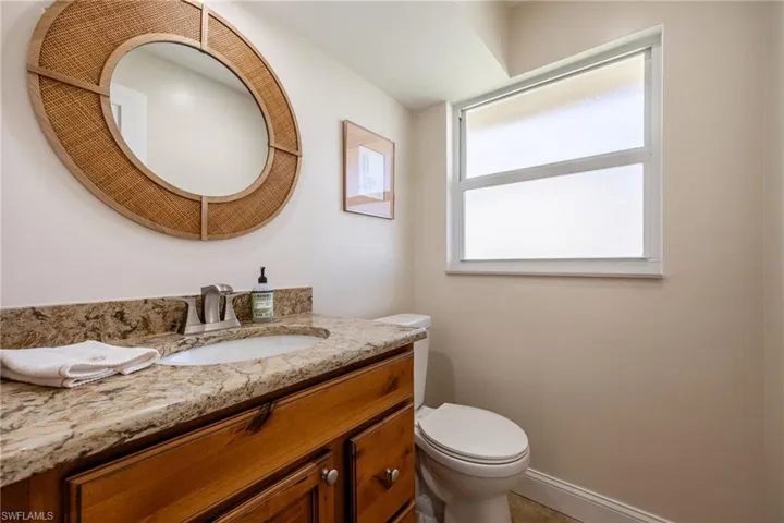 Bathroom featuring toilet, vanity, and baseboards