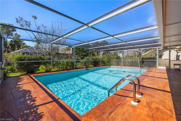 Outdoor pool with glass enclosure and a patio area