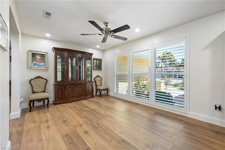 Sitting room with a ceiling fan, light wood-style flooring, and baseboards