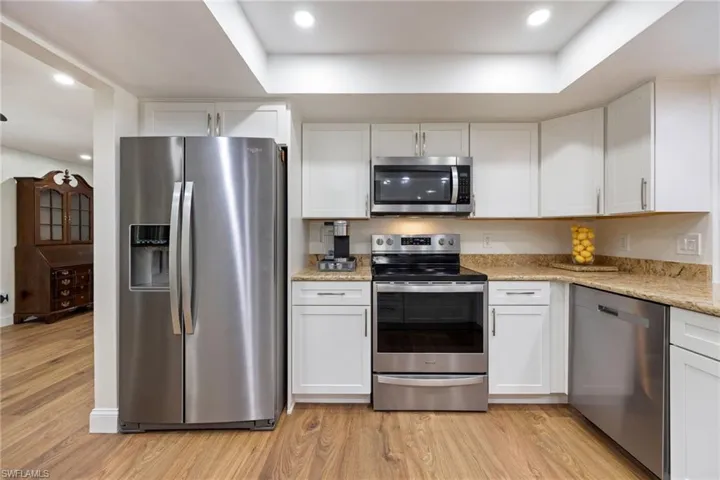Kitchen featuring white cabinets, light wood-type flooring, and appliances with stainless steel finishes