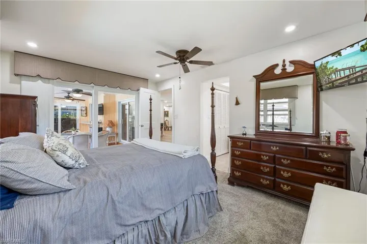 Carpeted bedroom featuring multiple windows and recessed lighting