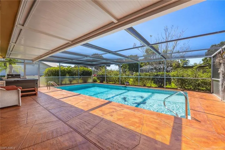 Pool featuring glass enclosure and a patio area