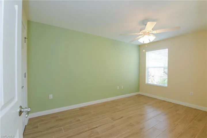 Empty room with light hardwood / wood-style floors and ceiling fan