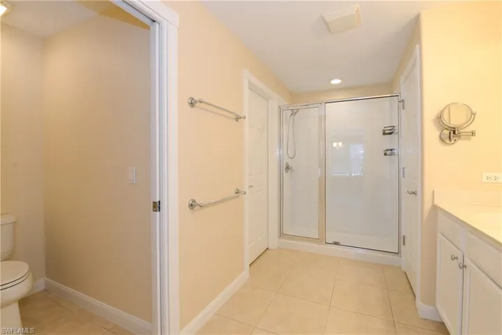Bathroom with vanity, tile patterned flooring, toilet, and walk in shower